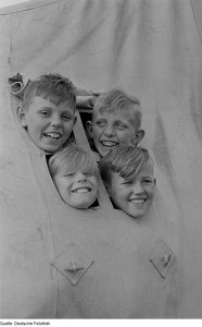 Vier Jungen aus dem Zeltfenster schauend. Foto: Renate Rössig, Roger Rössig, Deutsche Fotothek, CC-BY-SA-3.0